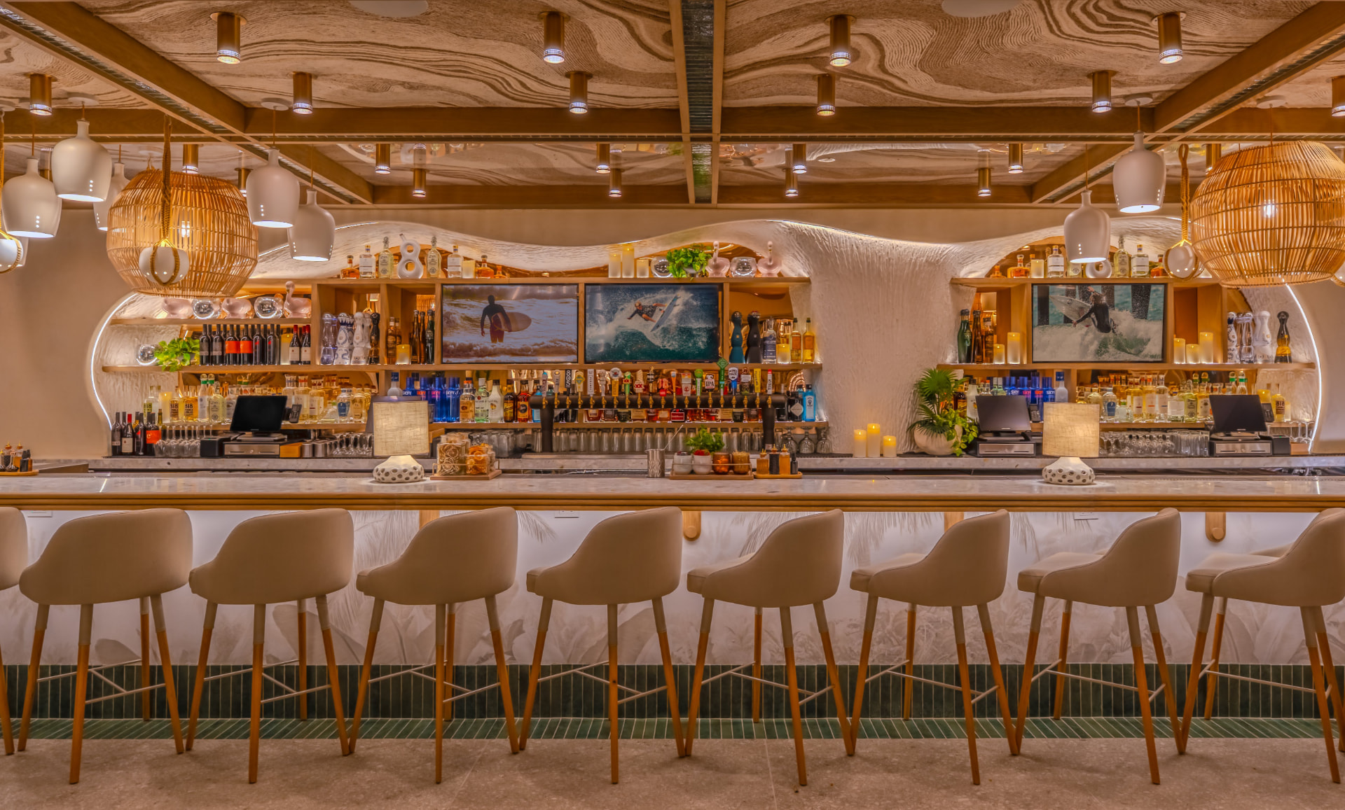 Sandbar Cocina y Tequila bar with sculpted white walls, rattan pendants and woven barstools